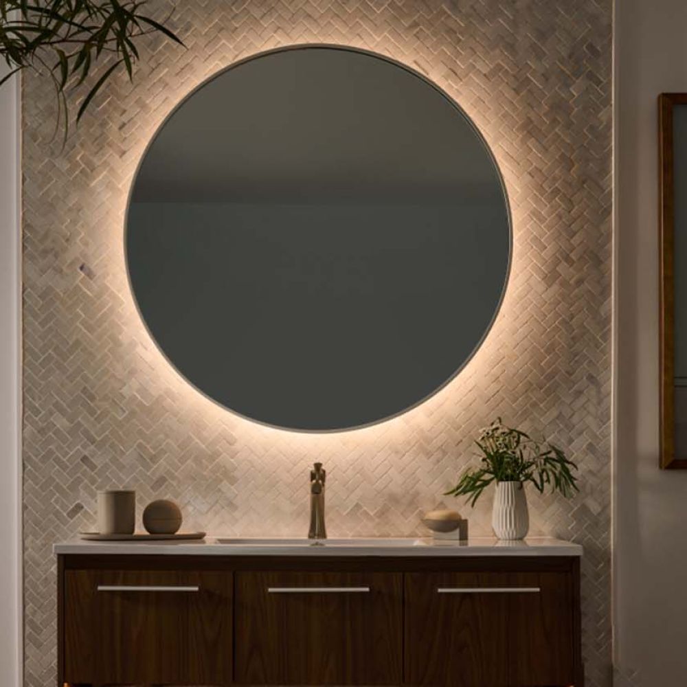 Round backlit mirror above wooden vanity with warm ambient lighting